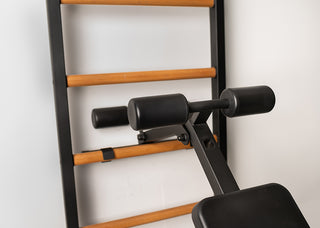 Drabinka gimnastyczna BenchK 723 (czarna lub biała) z metalowym, montowanym na stałe drążkiem do podciągania z 6 uchwytami, poręczami z podparciem pod plecy oraz rozbudowaną ławką