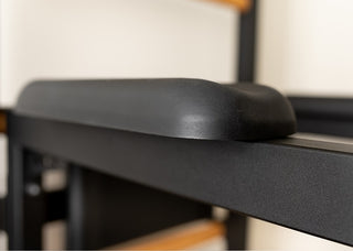 Drabinka gimnastyczna BenchK 723 (czarna lub biała) z metalowym, montowanym na stałe drążkiem do podciągania z 6 uchwytami, poręczami z podparciem pod plecy oraz rozbudowaną ławką