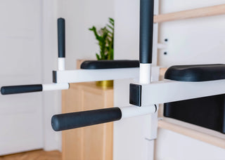 Drabinka gimnastyczna BenchK 723 (czarna lub biała) z metalowym, montowanym na stałe drążkiem do podciągania z 6 uchwytami, poręczami z podparciem pod plecy oraz rozbudowaną ławką