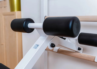 Drabinka gimnastyczna BenchK 723 (czarna lub biała) z metalowym, montowanym na stałe drążkiem do podciągania z 6 uchwytami, poręczami z podparciem pod plecy oraz rozbudowaną ławką